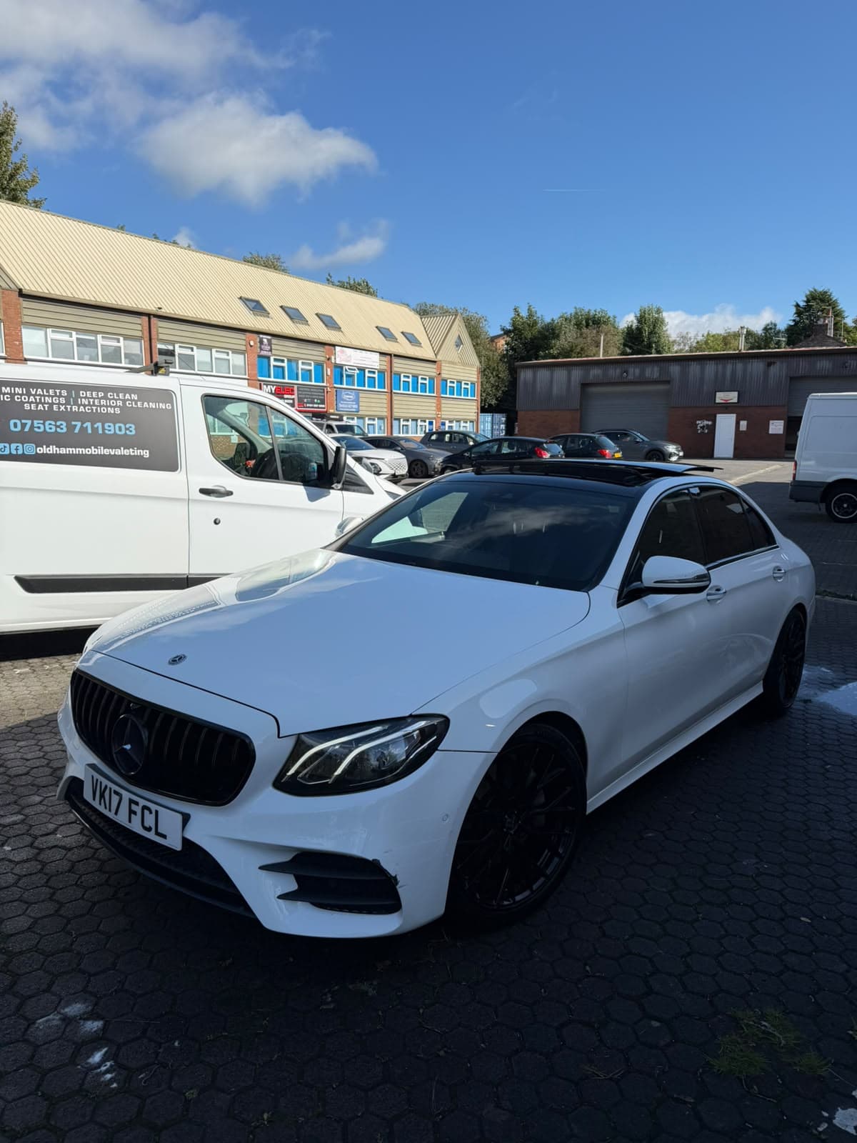A white Mercedes saloon parked beside the OMV van after a valet